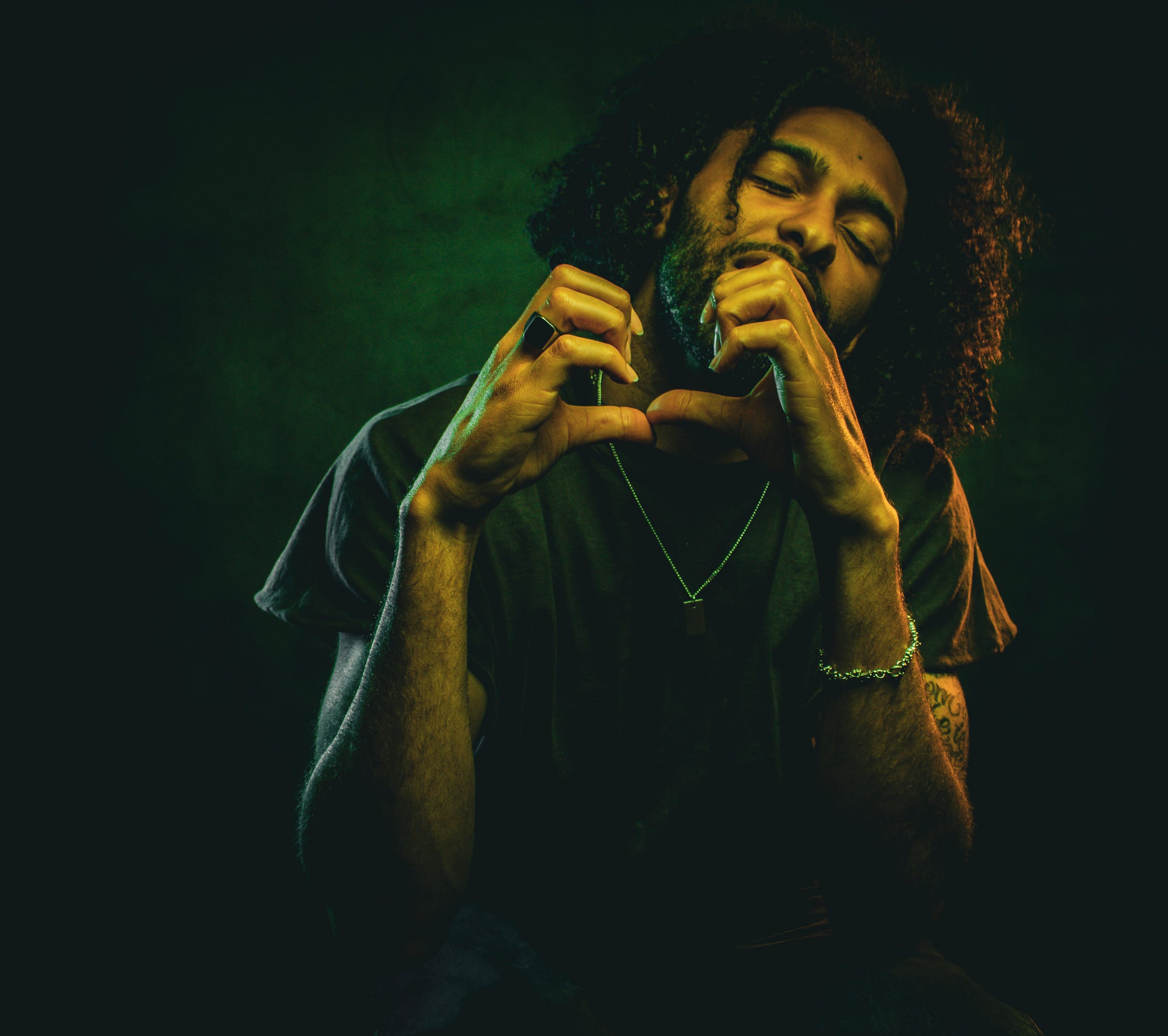 Studio portrait lit in green and amber